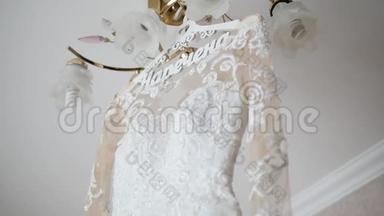 新娘`的礼服挂在灯上，婚纱挂在新娘`的房间里，白色婚纱挂在上面